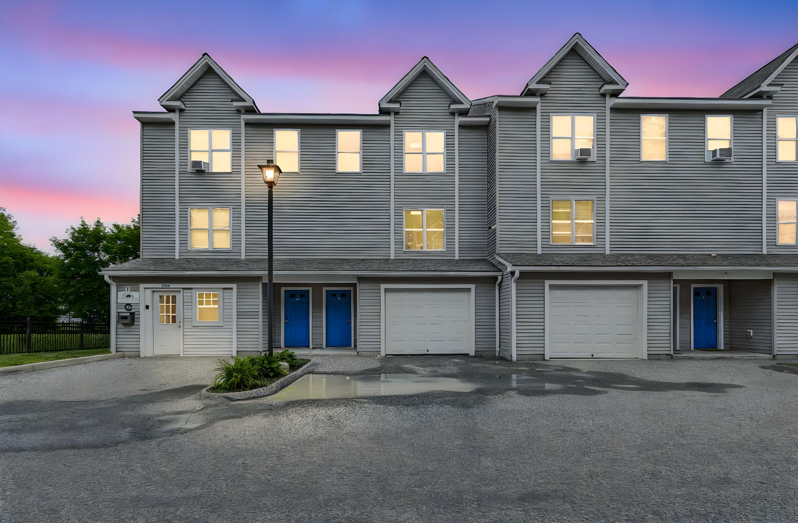 The Chestnut Street townhomes at dusk, windows lit against a pink and blue sky