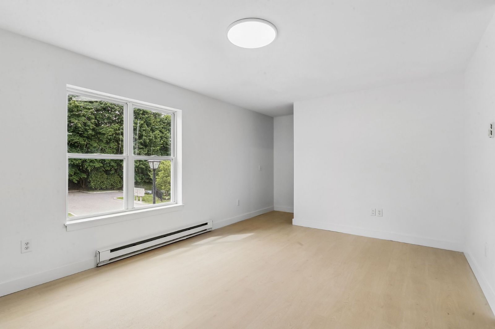 Bright living area with a large window and light wood-look flooring