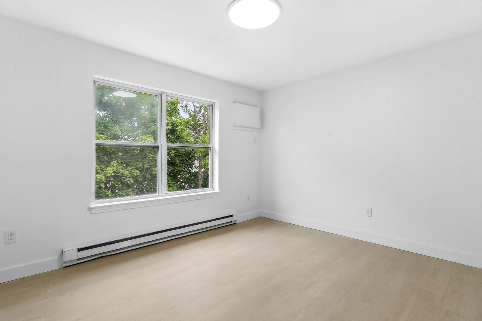 Room with a large window looking onto trees