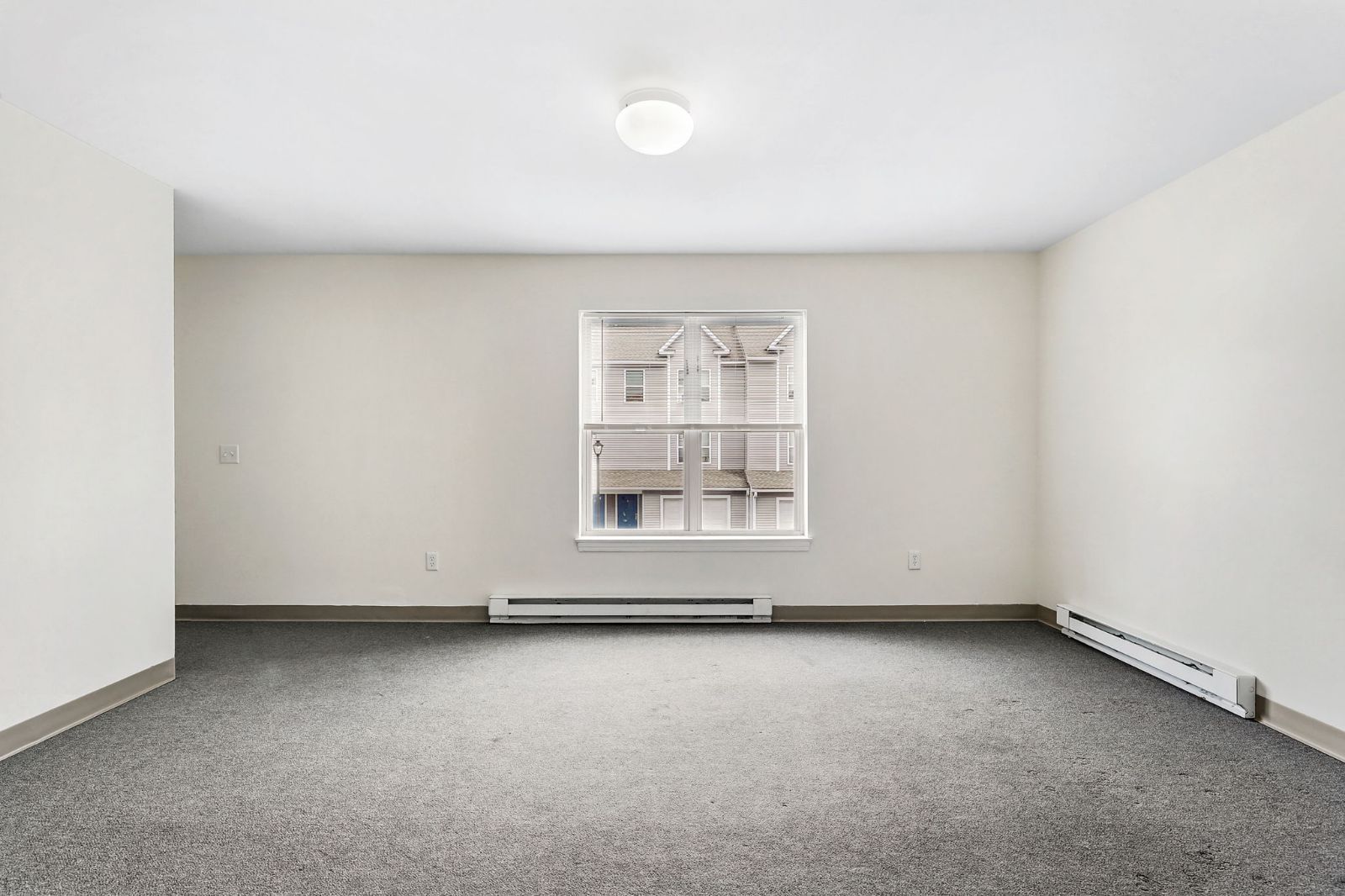 Carpeted living room with a window