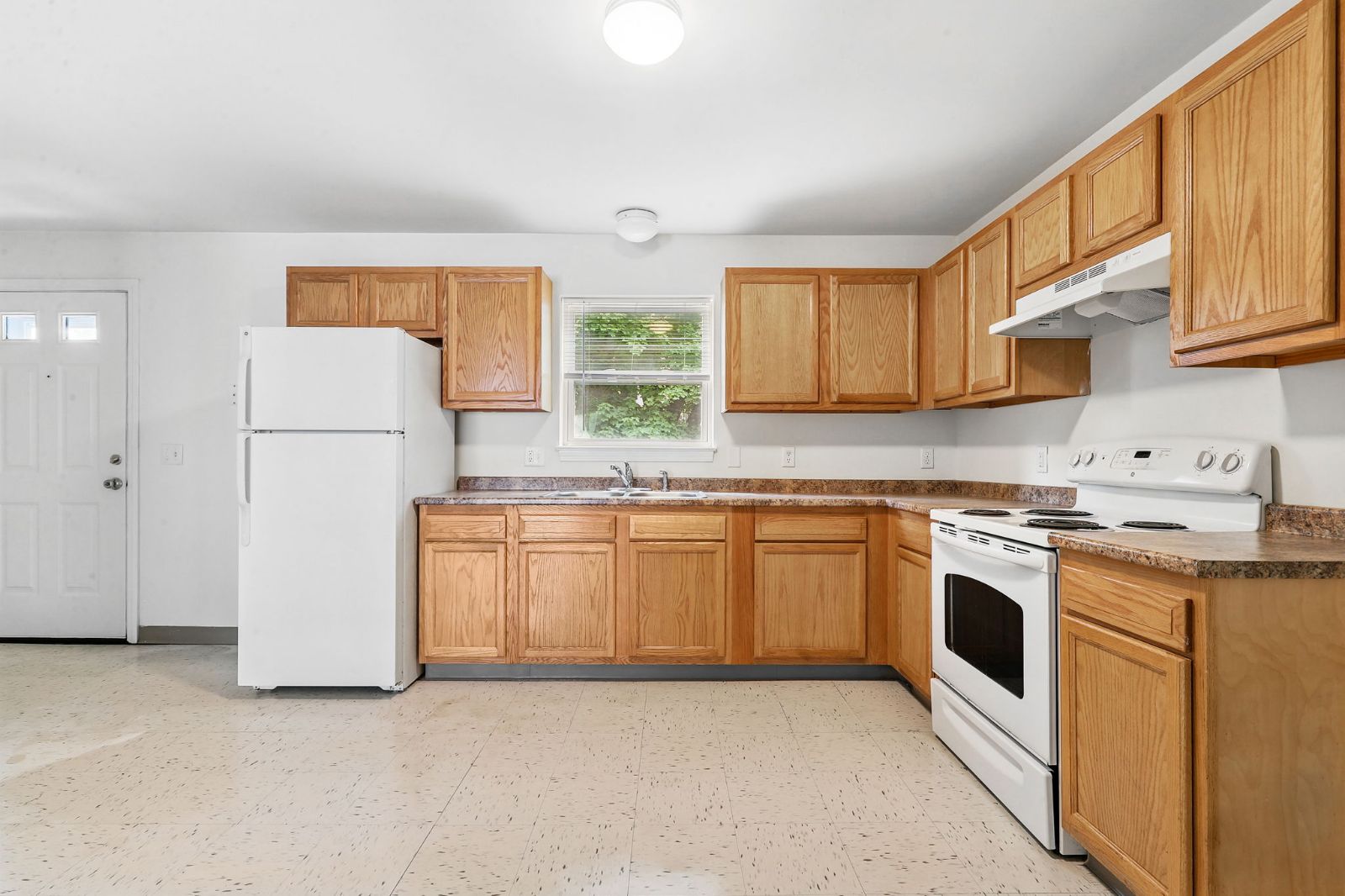 Kitchen with oak cabinets, white range and refrigerator