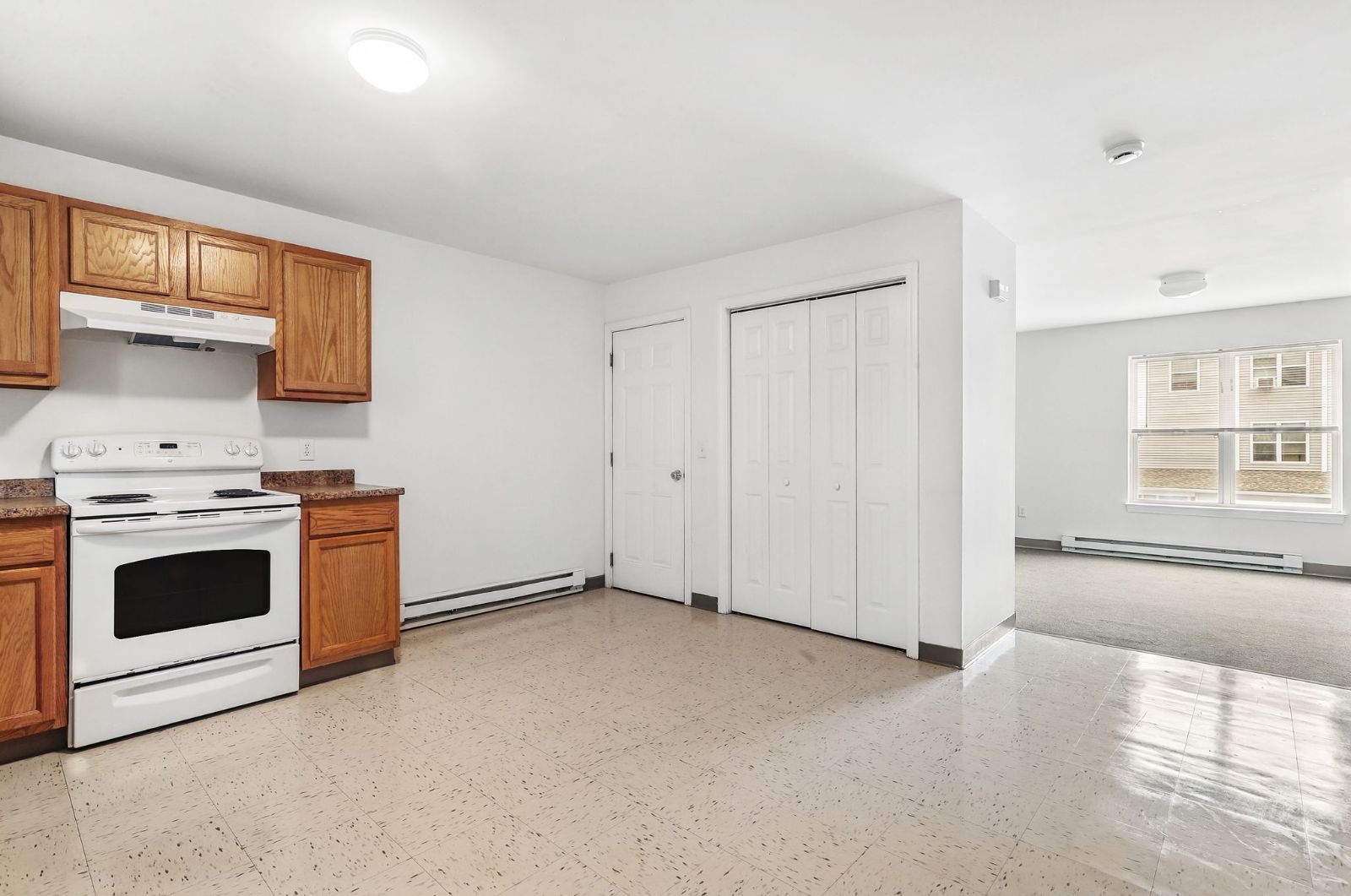 Kitchen opening to a living area with closets
